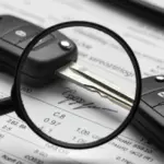 Taxas camufladas em financiamentos automotivos 2025: identifique e evite Chave de carro com lupa, simbolizando a atenção aos detalhes em contratos de financiamento automotivo.