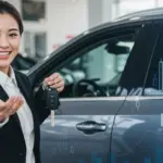 FGTS para Carro Novo 2025: Abata Até 80% do Financiamento Pessoa sorrindo com chaves de carro novo, simbolizando a conquista da compra com FGTS.
