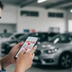 Score de crédito baixo: 3 estratégias para financiar carro em 2025 Pessoa preocupada olhando para o score de crédito baixo no celular, com concessionária de veículos ao fundo.