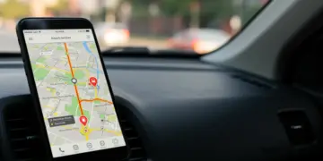 Smartphone exibindo um aplicativo de navegação GPS com trânsito em tempo real e rota otimizada, destacando a economia de combustível.